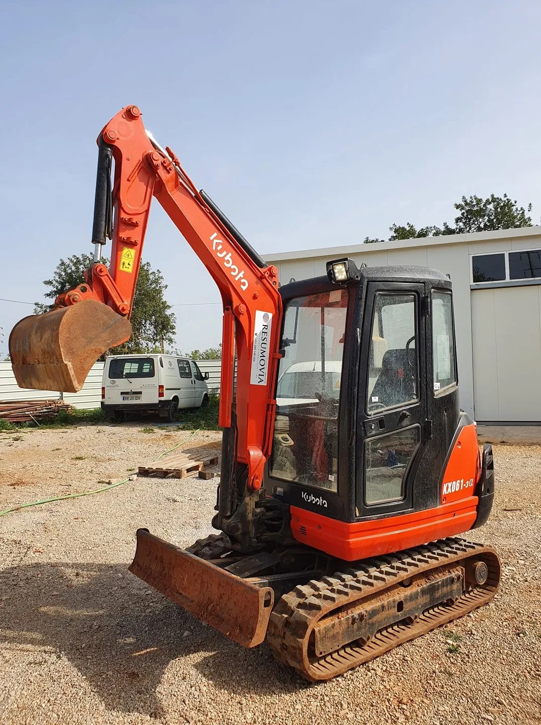 Giratória Kubota da Resumovia num estaleiro, com a carrinha da empresa ao fundo