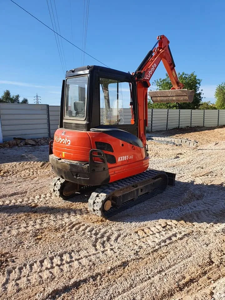 Giratória Kubota em movimentação de terras, junto a um muro novo