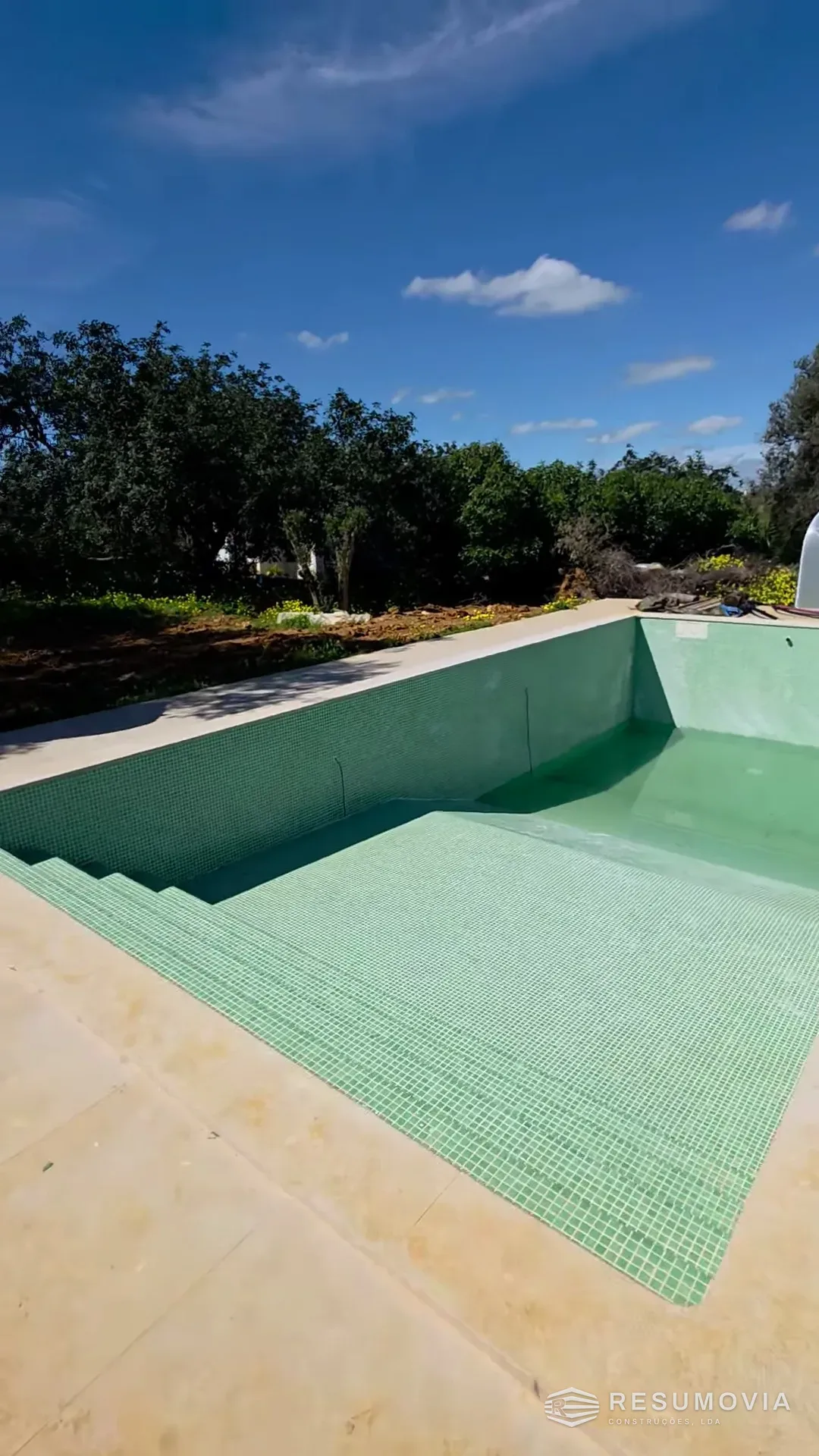 A piscina revestida a mosaico verde