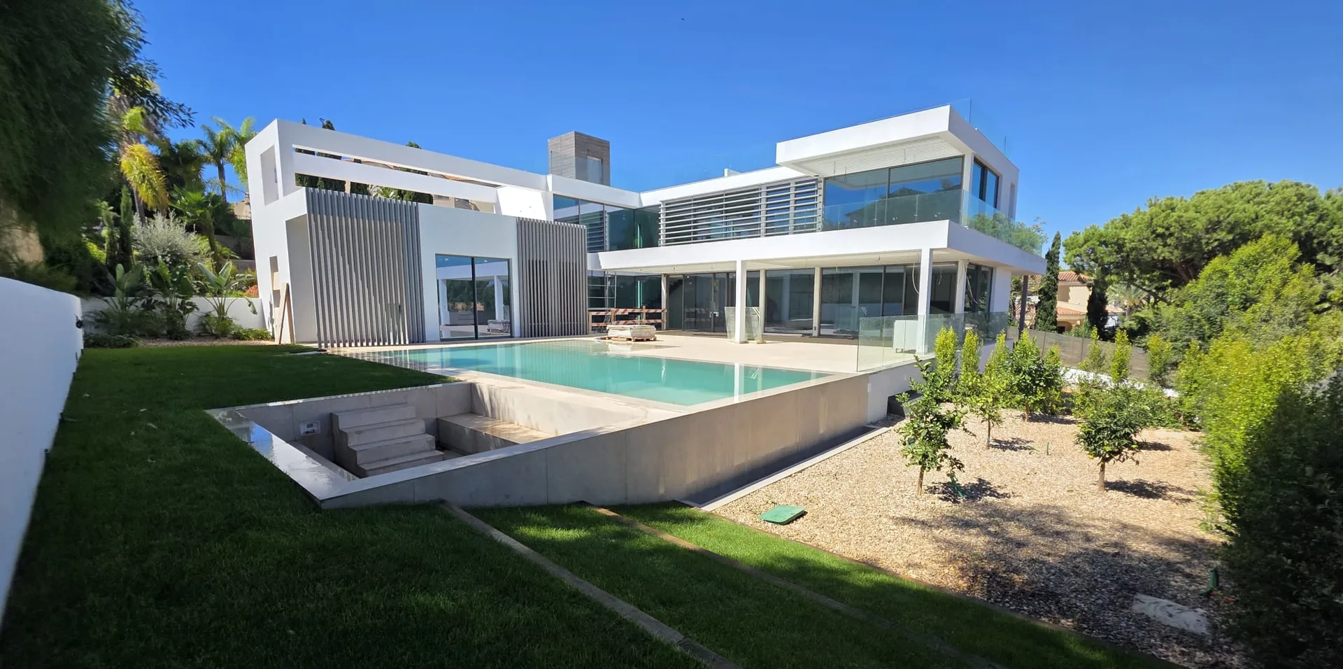 La maison vue du jardin, avec la piscine devant